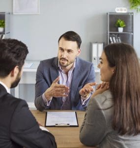 image of couple meeting with lawyer for a post about 10 reasons why aspiring franchisees need a franchise attorney